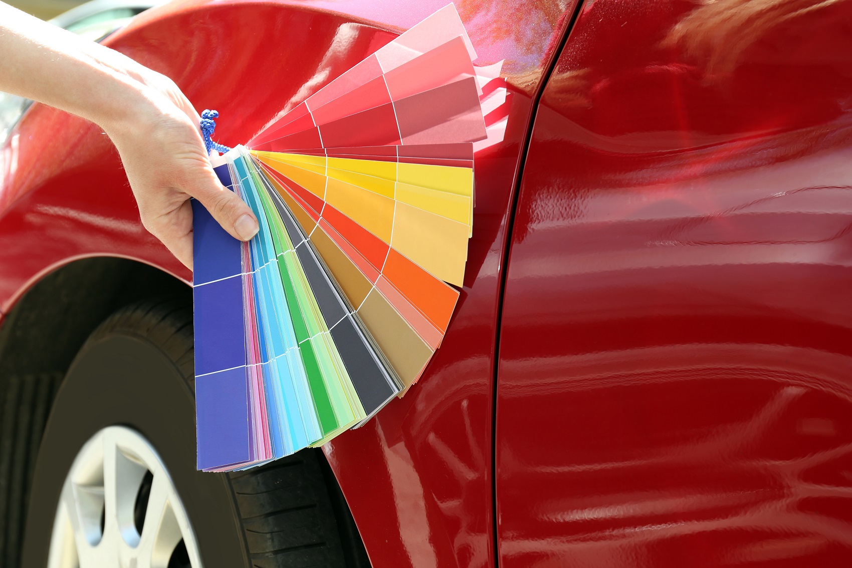 Woman choosing a car paint color from color samples