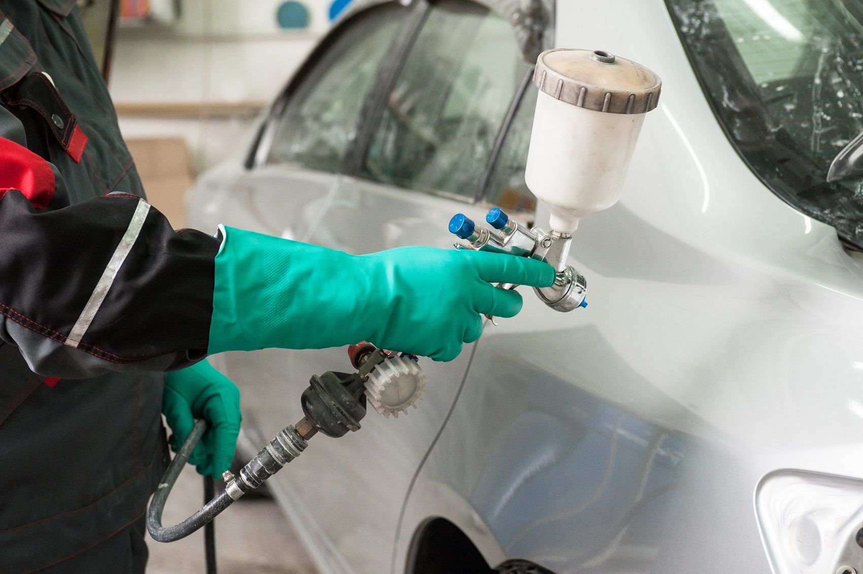 Automotive technician painting a car